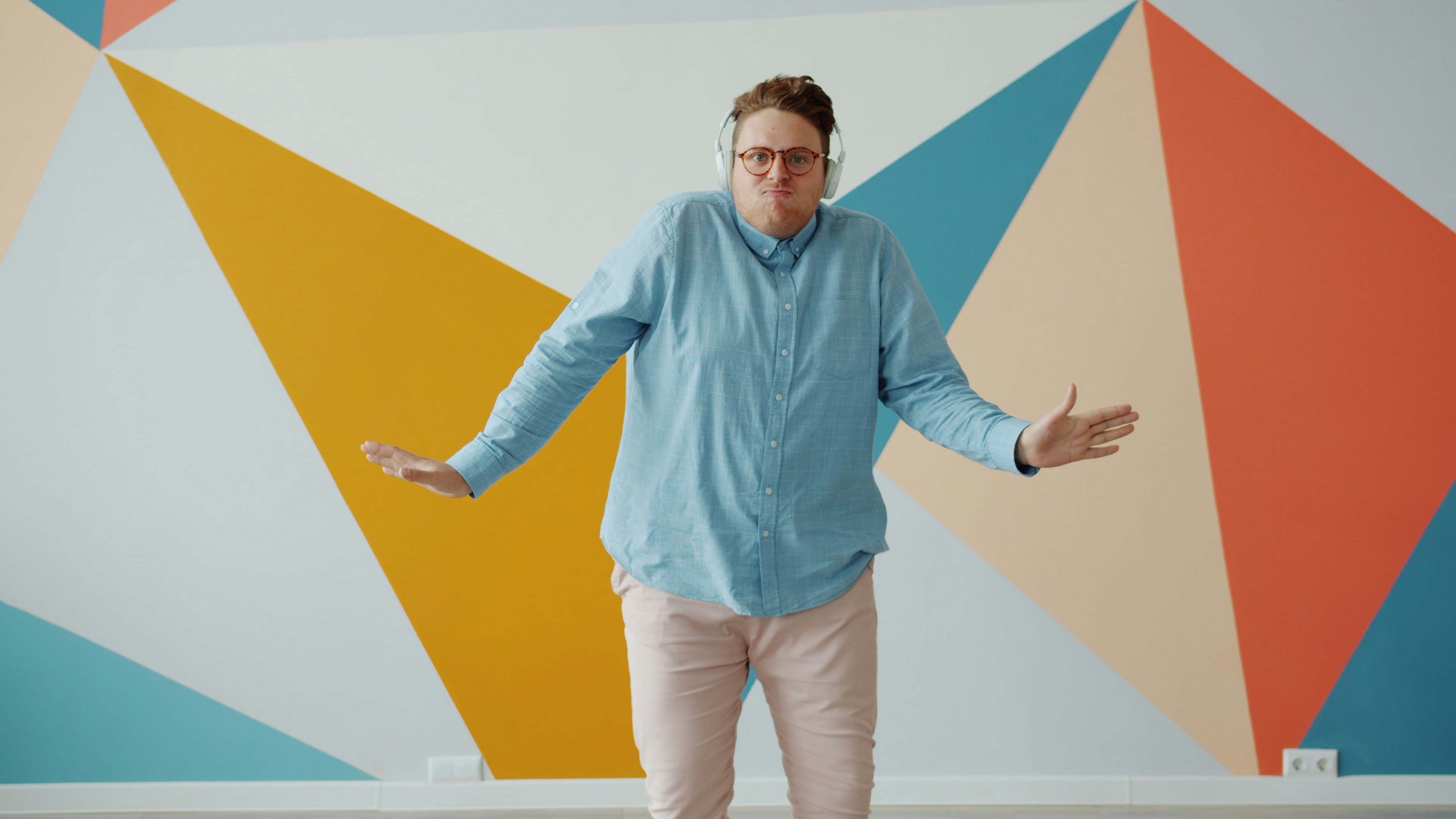 Man dancing in front of colorful geometric wall