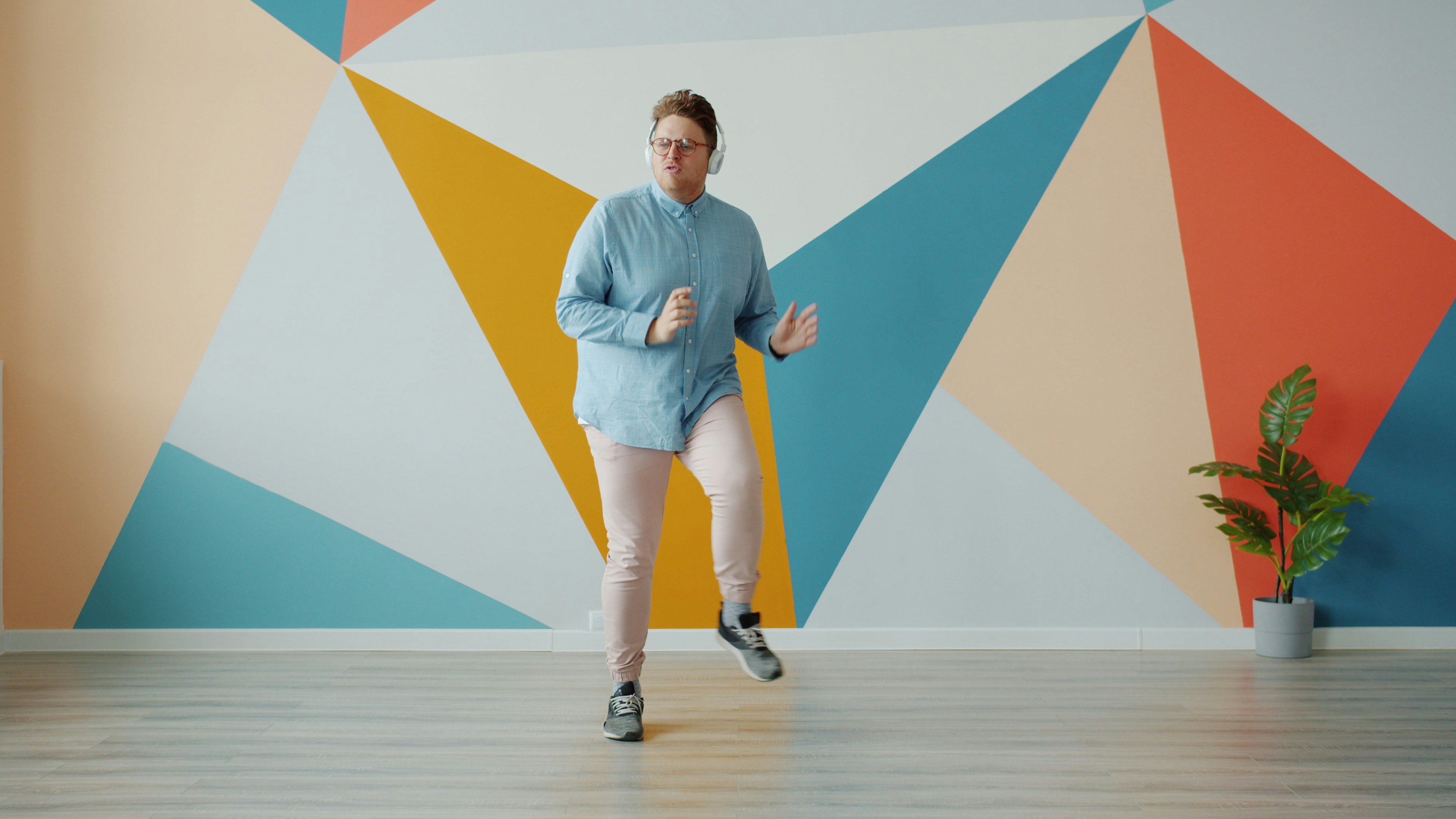 Person exercising in front of a colorful geometric wall