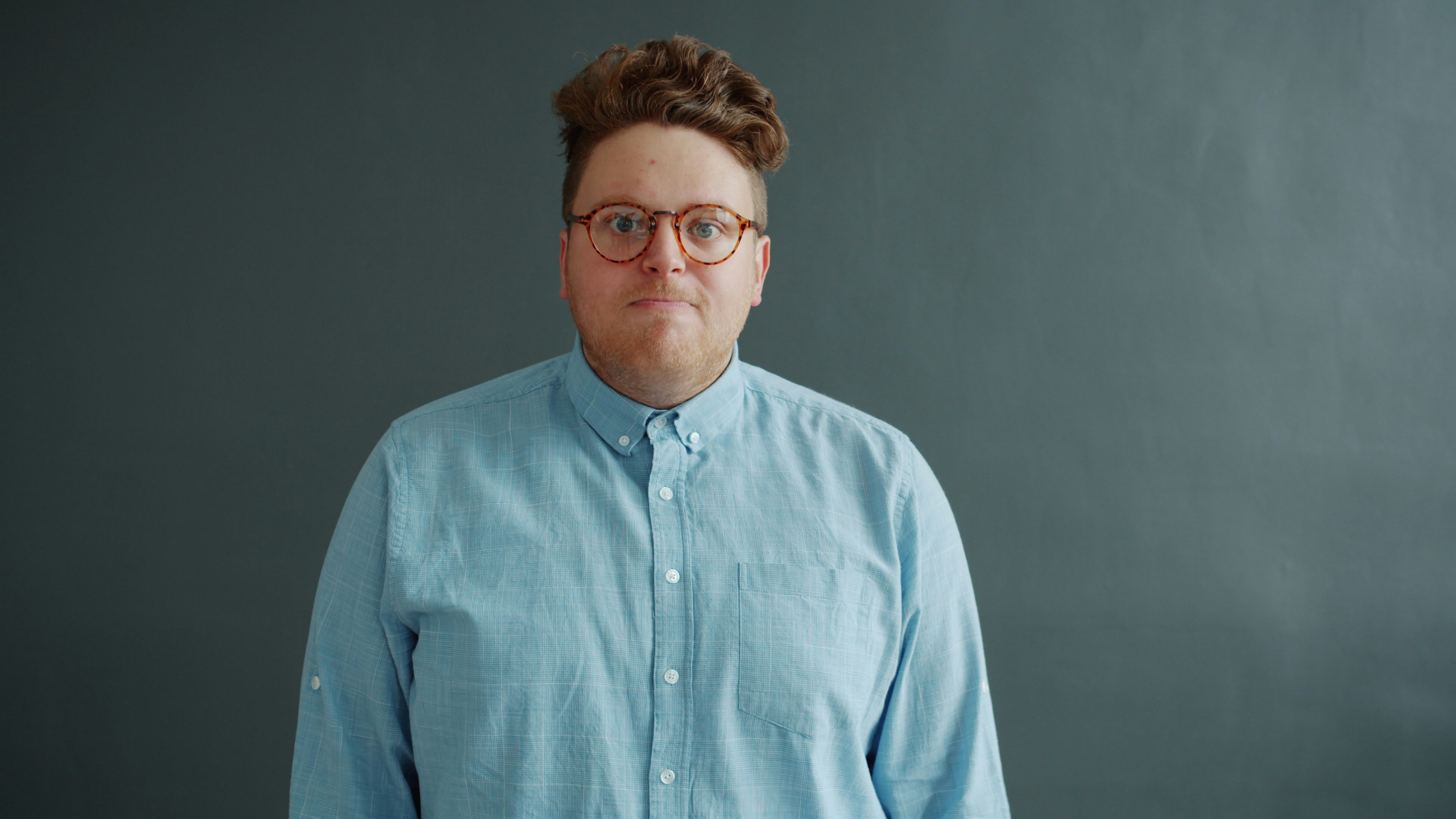 Mad guy in glasses is yelling gesturing looking at camera