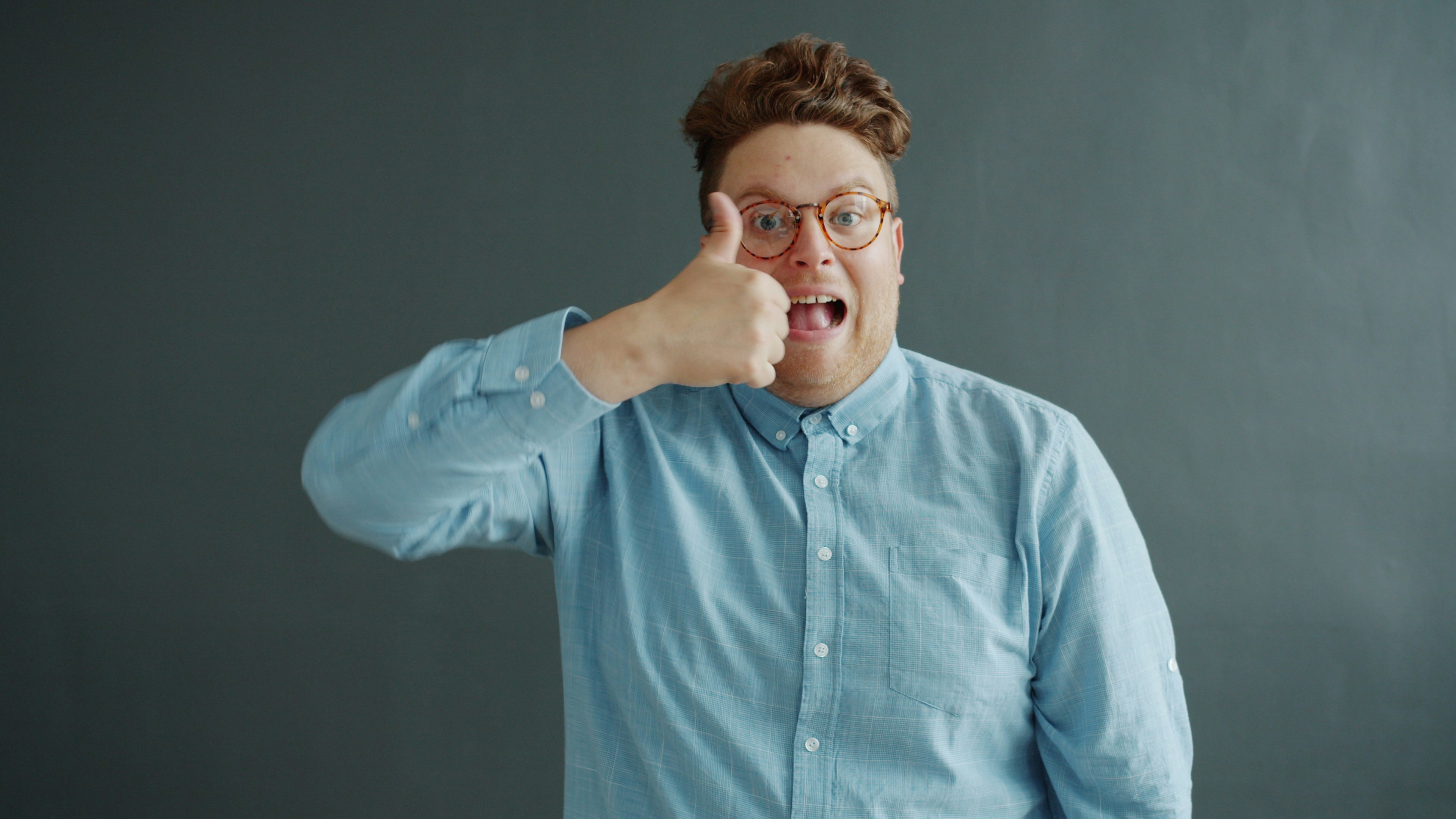 Man with glasses gives a thumbs up