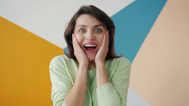 Woman with surprised expression against colorful background