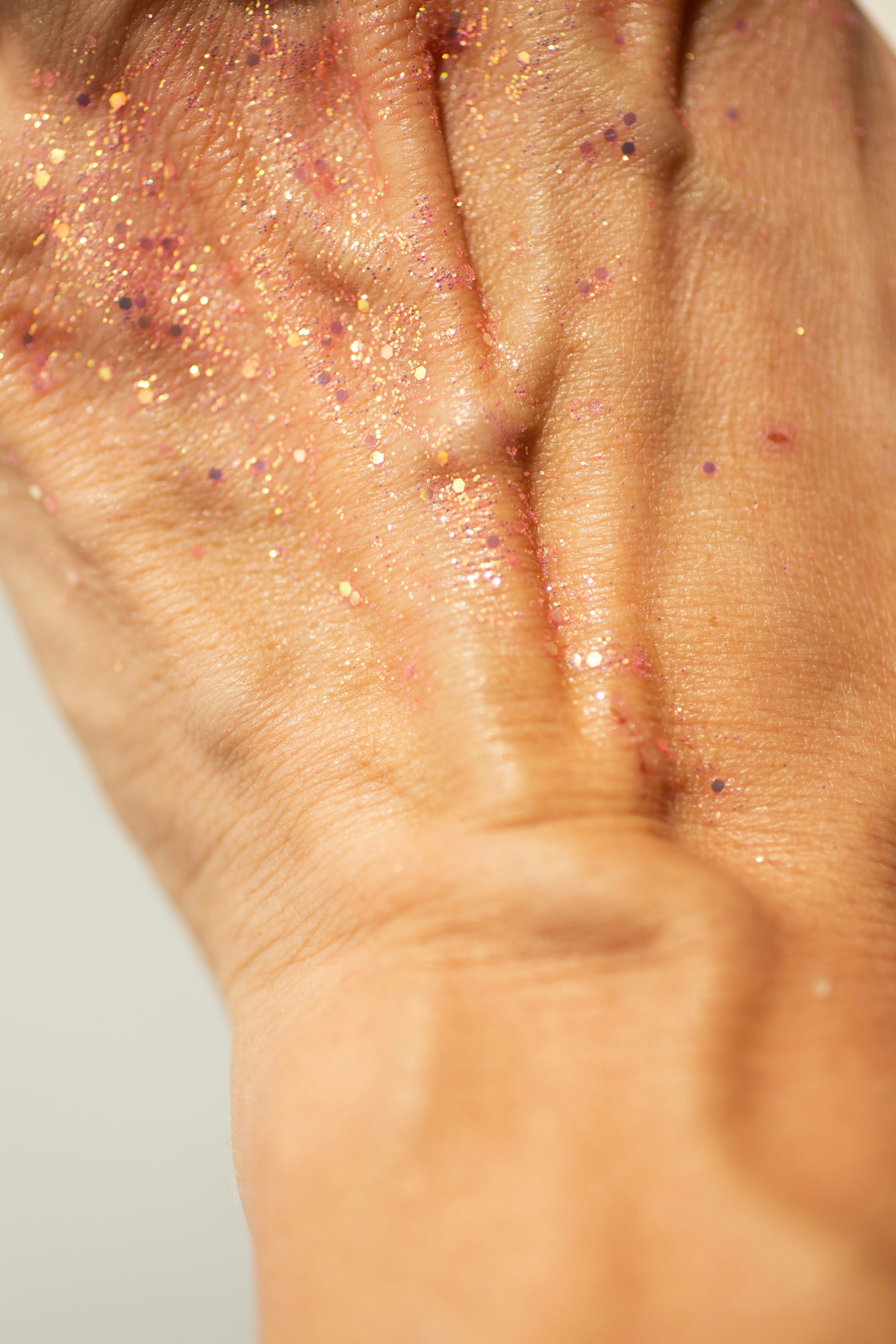 Close-up of a hand with glitter and makeup.