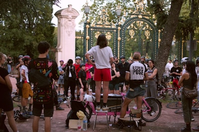Group of people gathered in park near ornate gate