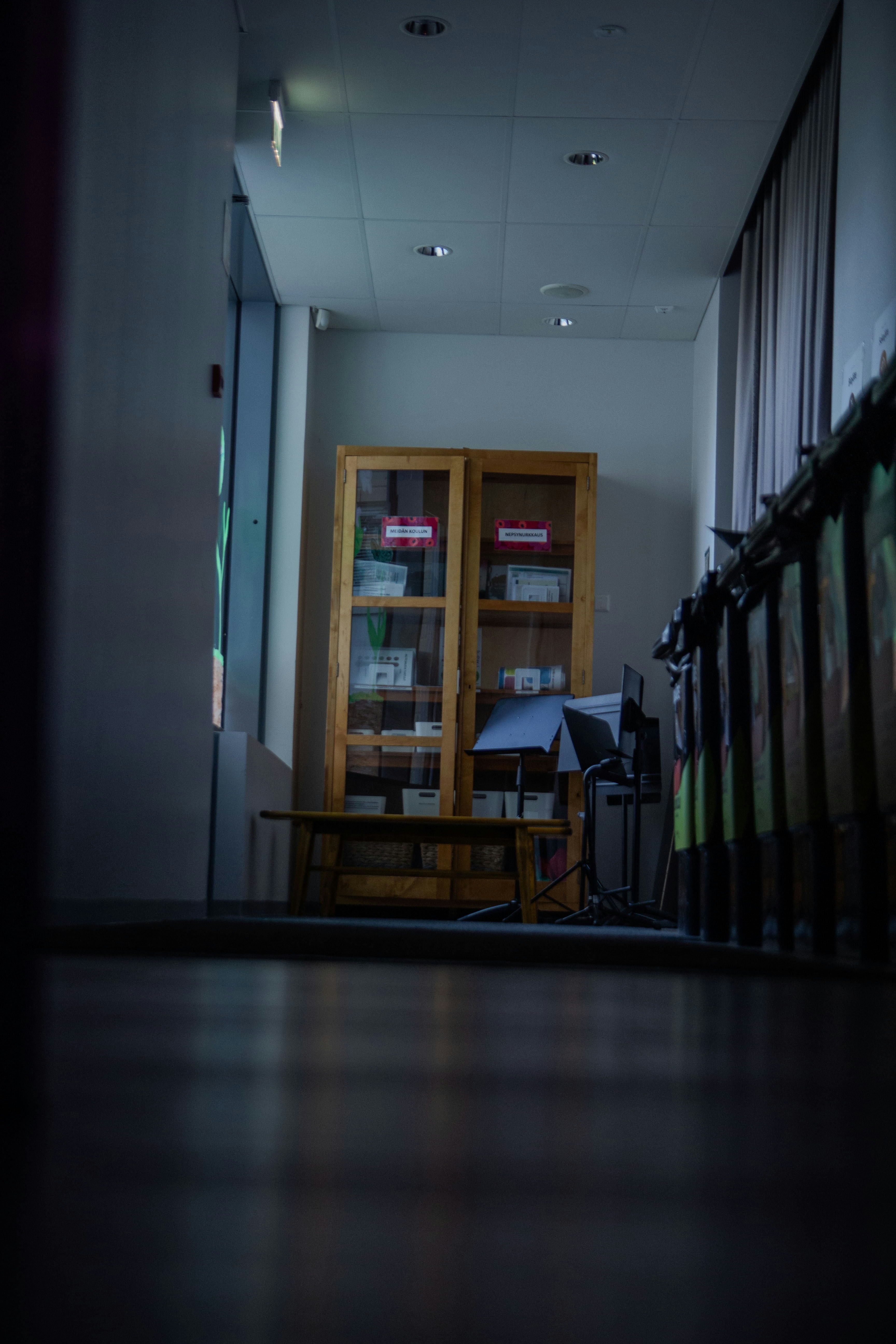 Wooden cabinet with items displayed in hallway.