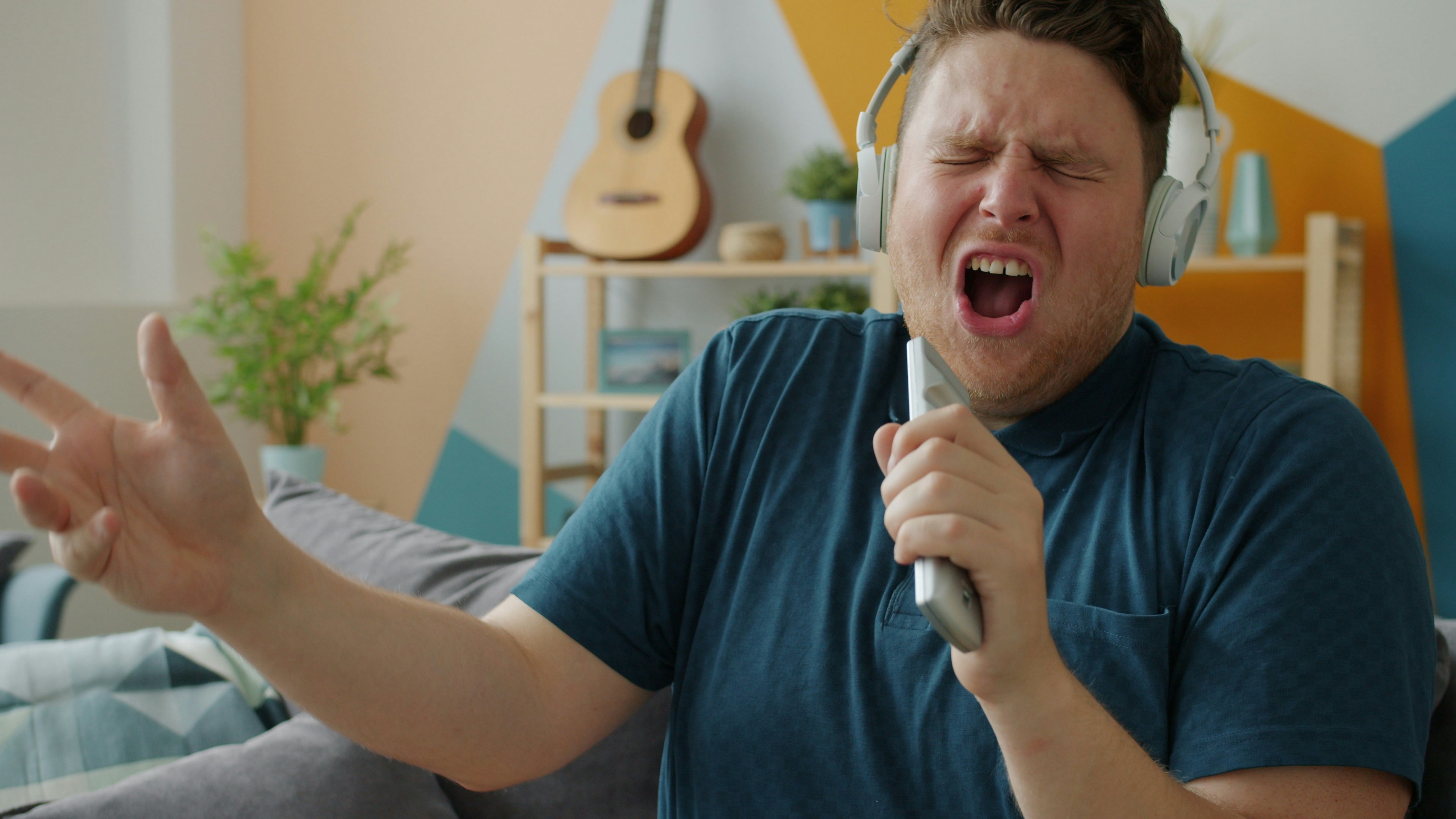 Man singing passionately while wearing headphones