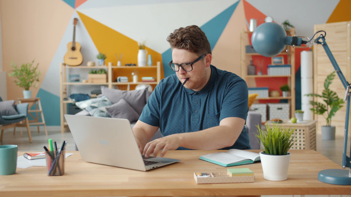 Man working on laptop at a colorful home office desk.