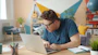 Man wearing glasses typing on a laptop at a desk.