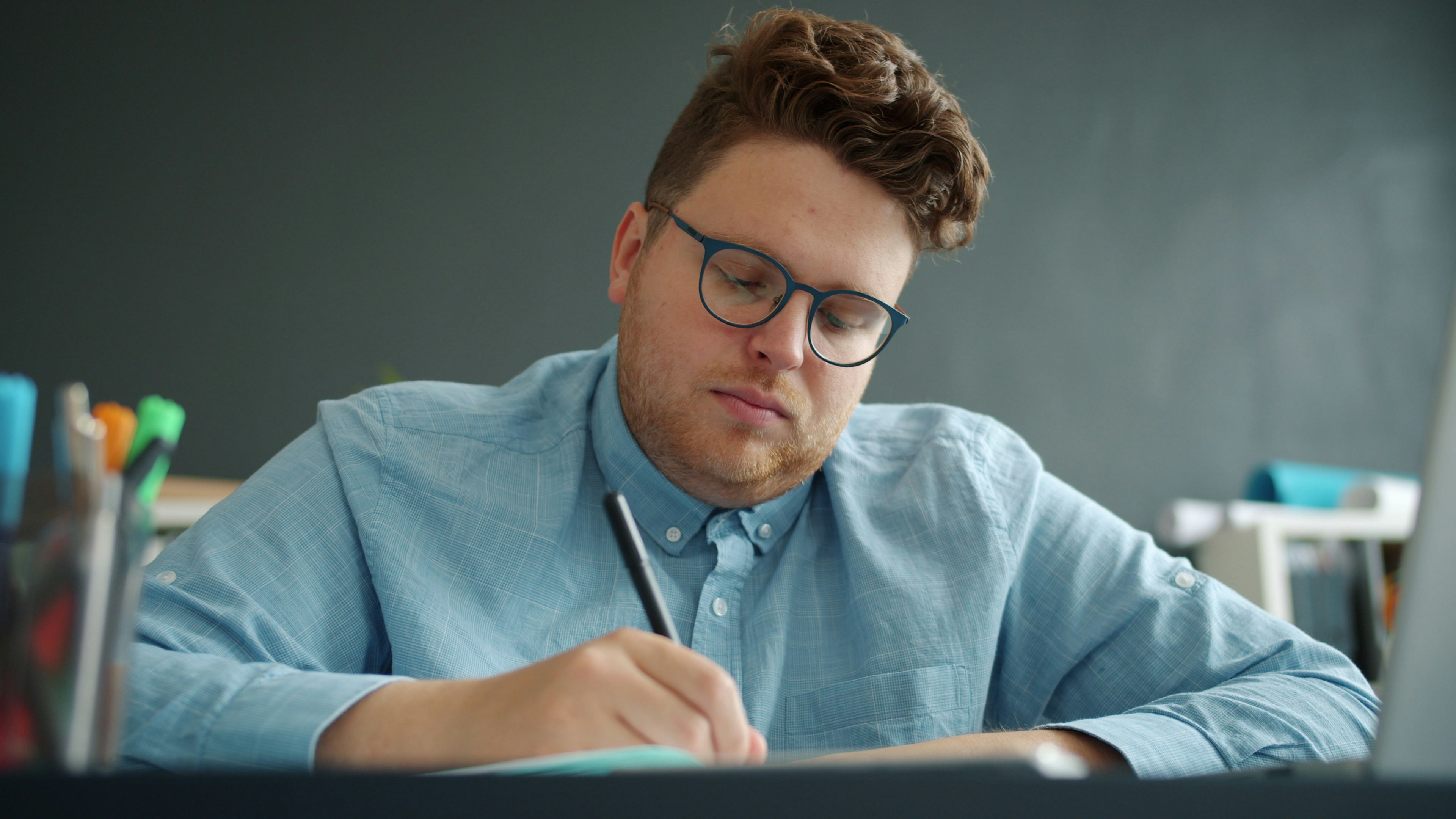 tired young man businessman writing working in office feeling exhausted from overwork. Modern lifestyle, job and business activities concept.