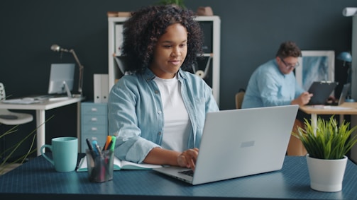 Woman working on a laptop in a modern office.