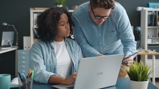 Two colleagues collaborating on a project at a desk.