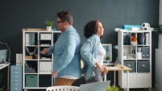 Man and woman back to back in office