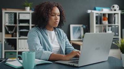 Young woman working on a laptop at a desk.