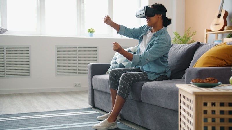 Woman wearing VR headset playing a game on a couch