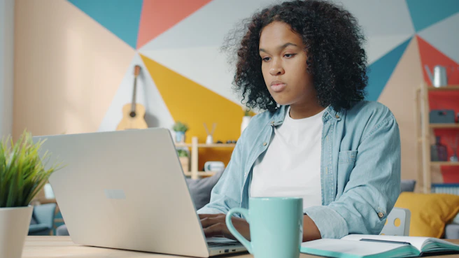 Young woman working on a laptop at home.