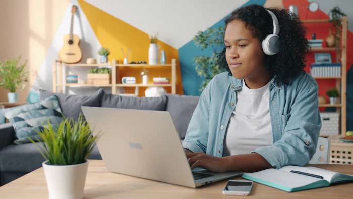 Woman with headphones studying on laptop