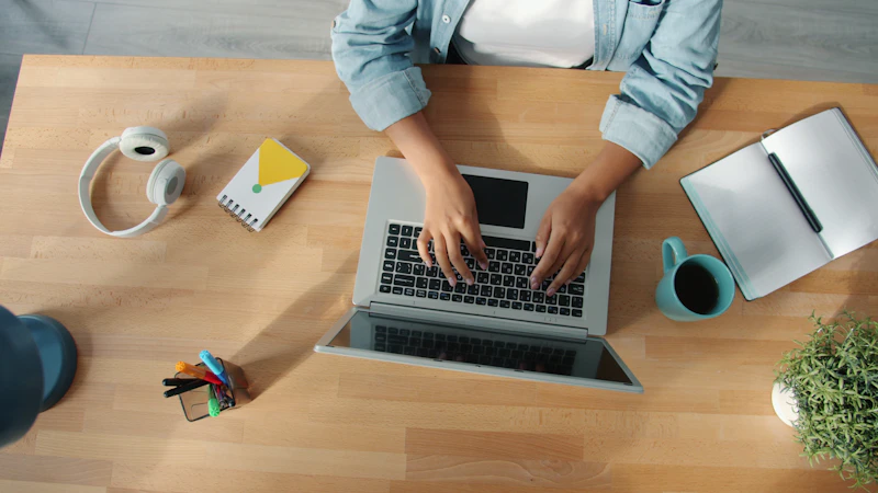 Personne tapant sur un ordinateur portable à un bureau en bo