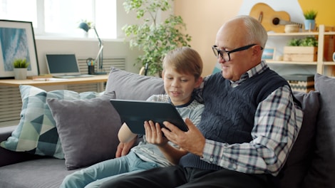 Grandfather and grandson looking at tablet on tablet.
