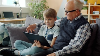 Grandfather and grandson looking at a tablet together.