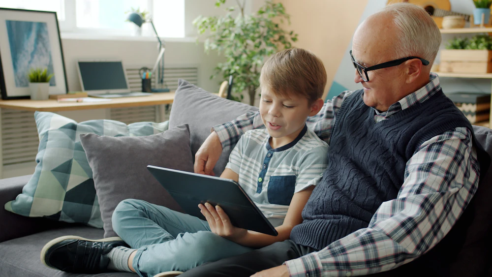 A grandfather and grandson looking at a tablet together