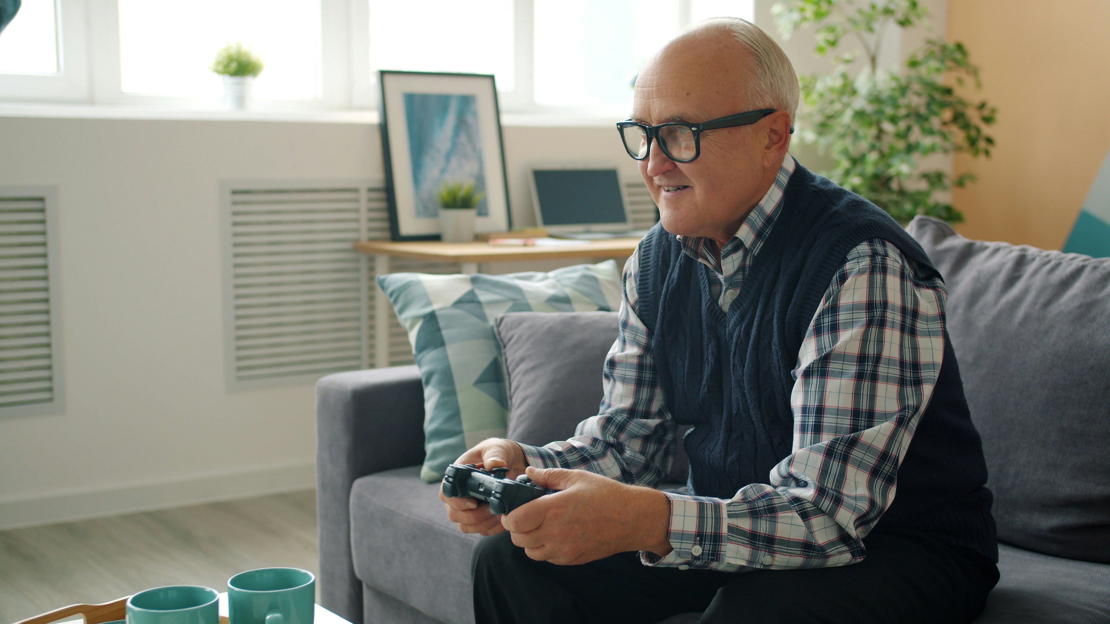 Elderly man playing video games on couch