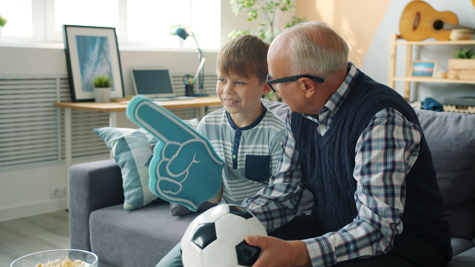 Grandfather and grandson watching sports at home