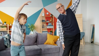 Grandfather and grandson exercising together indoors.
