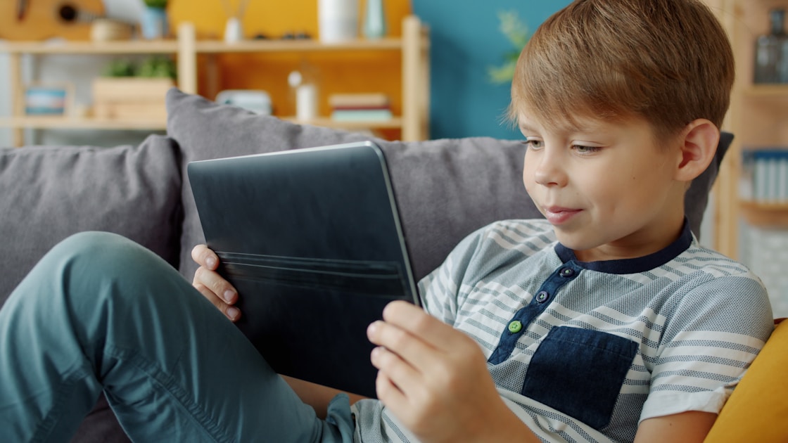 Boy using tablet on couch - screen time ADHD balance Sydney