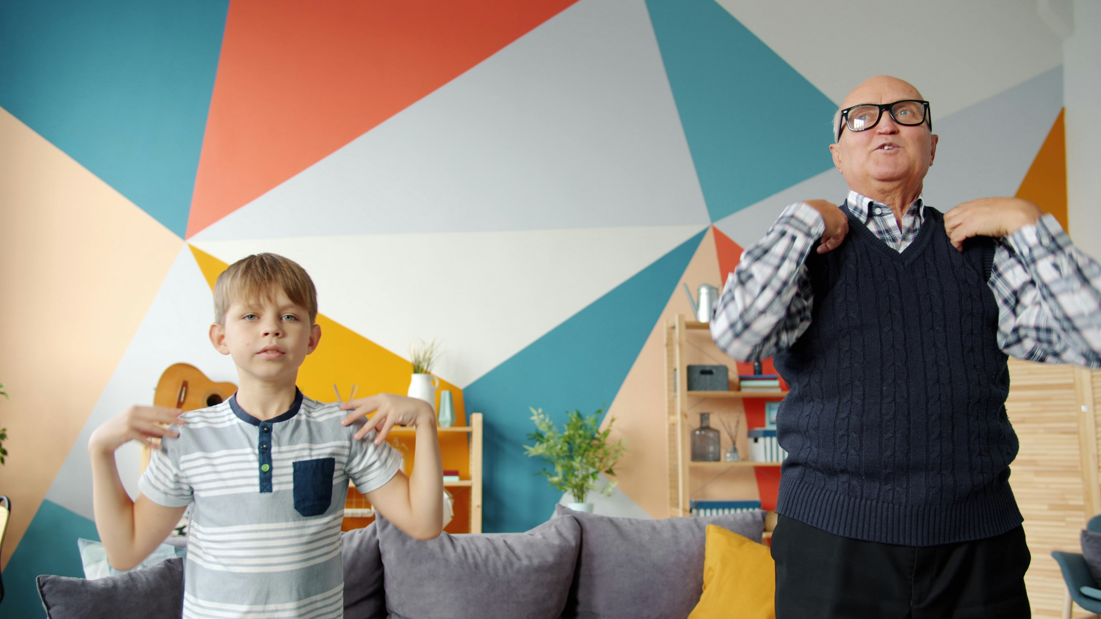 Grandfather and grandson doing exercises together at home.