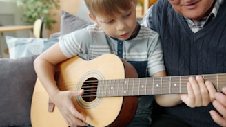 Boy learns guitar with grandfather's help