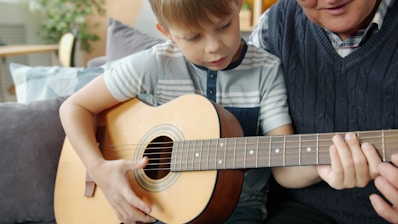 Boy learns guitar with grandfather's help