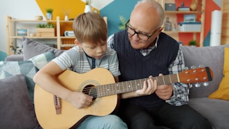 Grandfather teaching grandson to play guitar