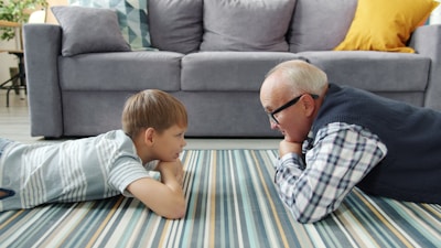 Grandfather and grandson lying on the floor talking.