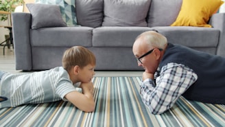 Grandfather and grandson lying on the floor talking.