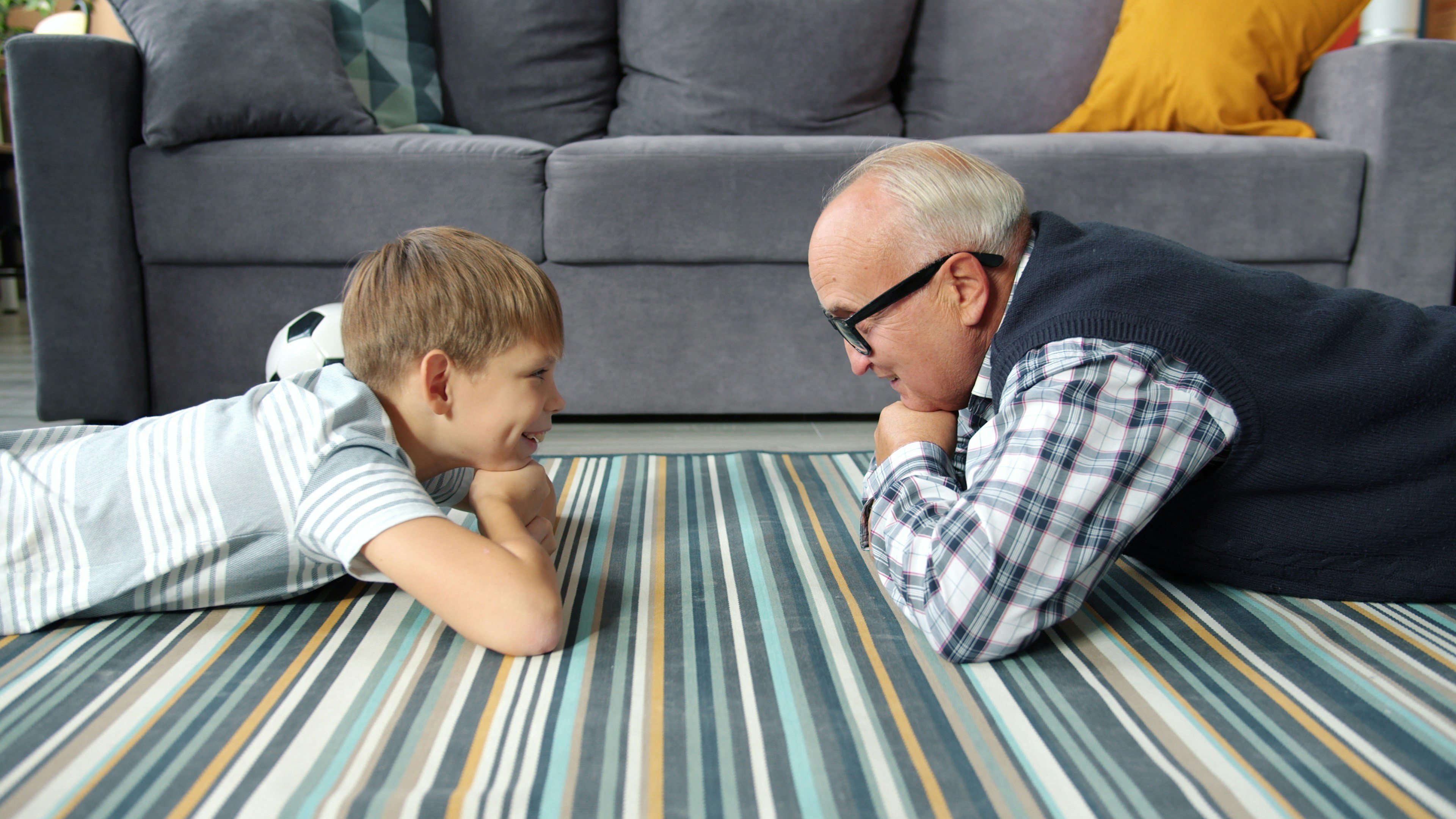 Grandfather and grandson lying on floor together