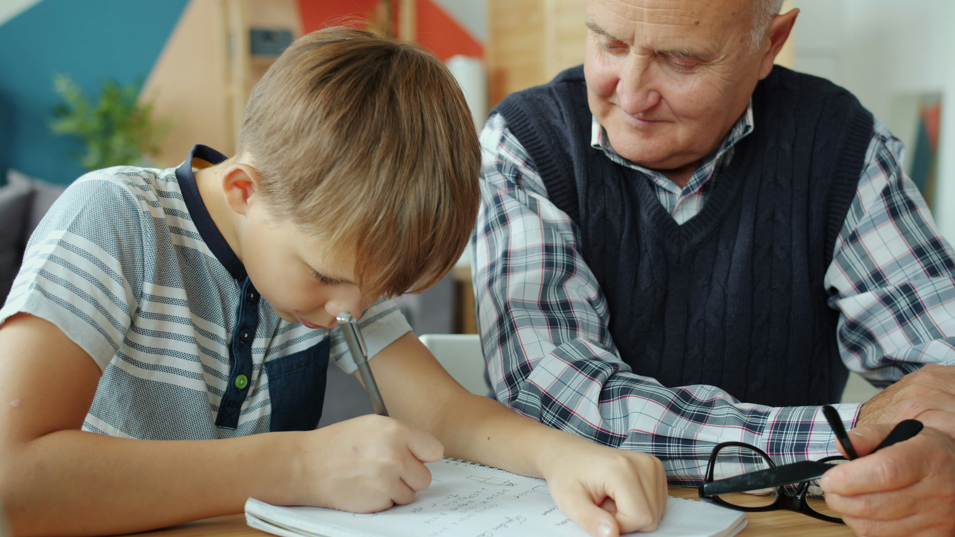 Grandfather helping grandson with homework