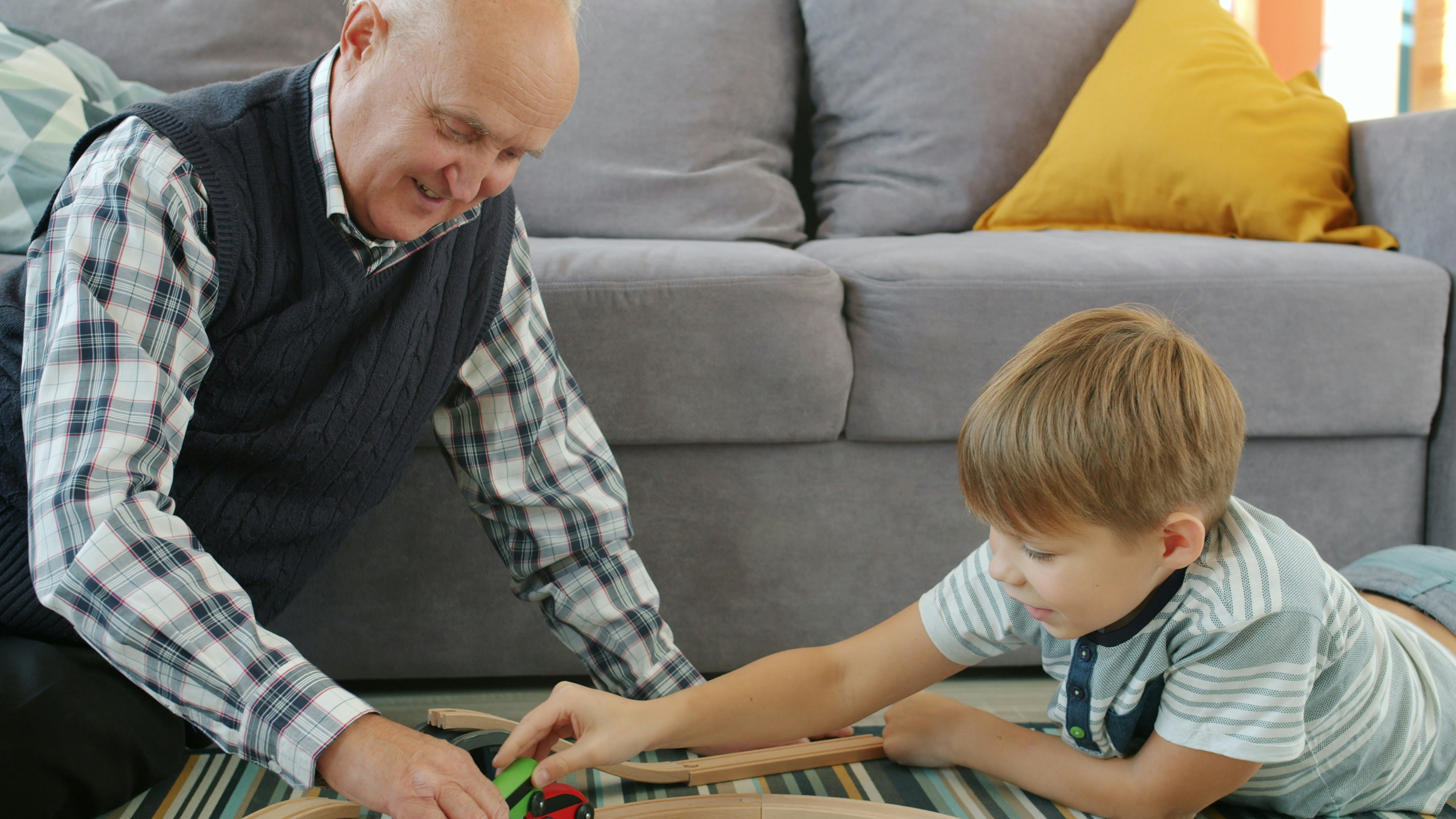 Grandfather and grandson playing with toy train