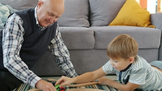 Grandfather and grandson playing with toy train