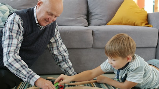 Grandfather and grandson playing with toy train