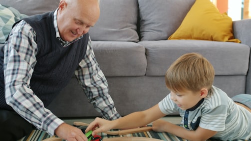 Grandfather and grandson playing with toy train