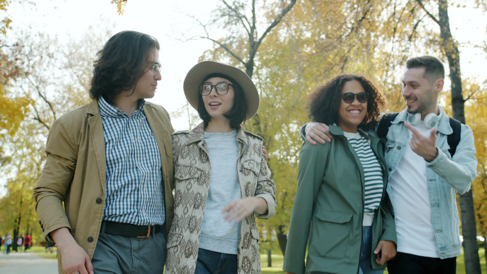 Four friends walking together in a park.