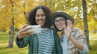 Two friends taking a selfie in a park.