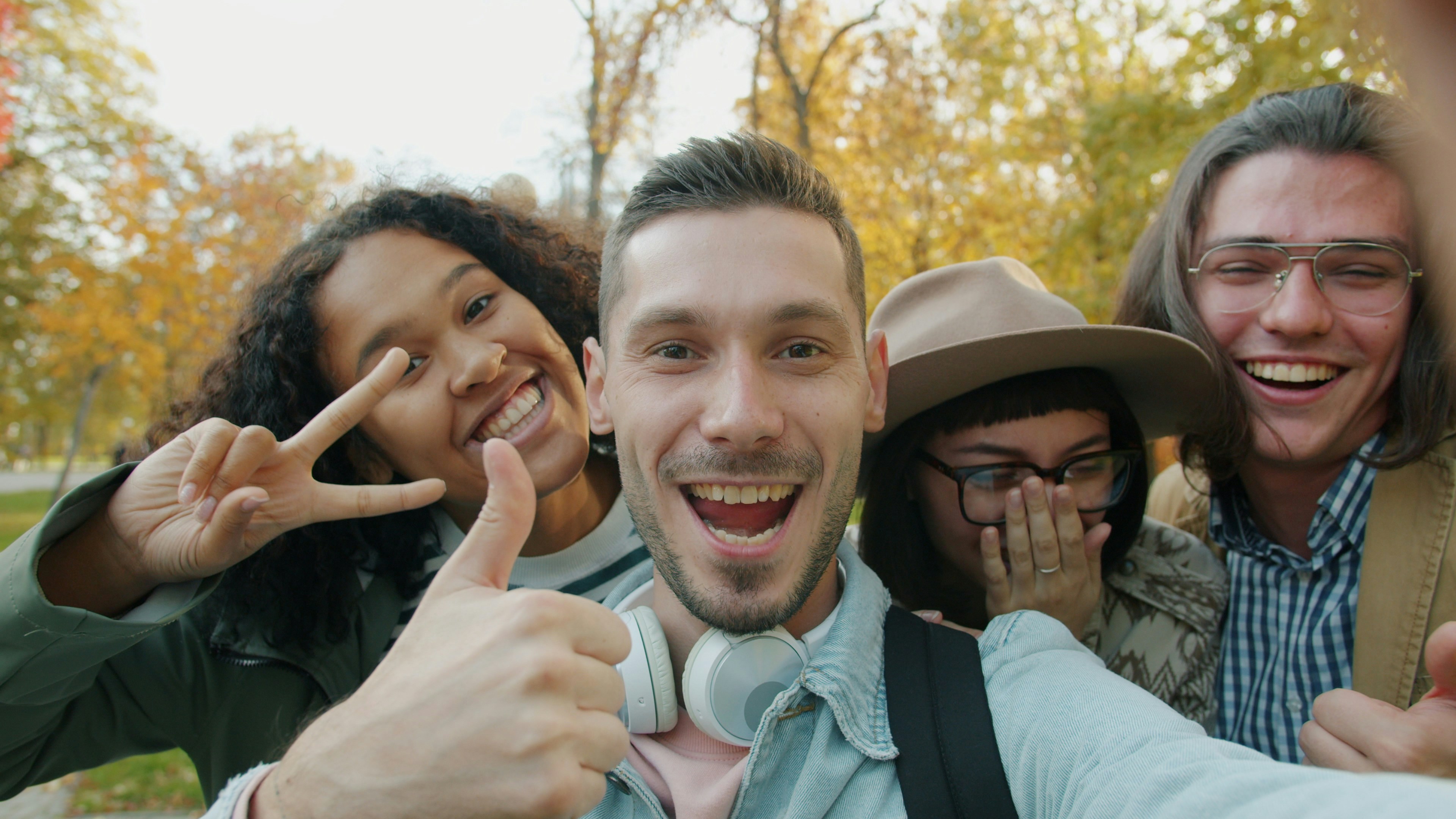 Four friends taking a happy selfie outdoors in autumn.