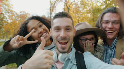 Four friends taking a happy selfie outdoors in autumn.