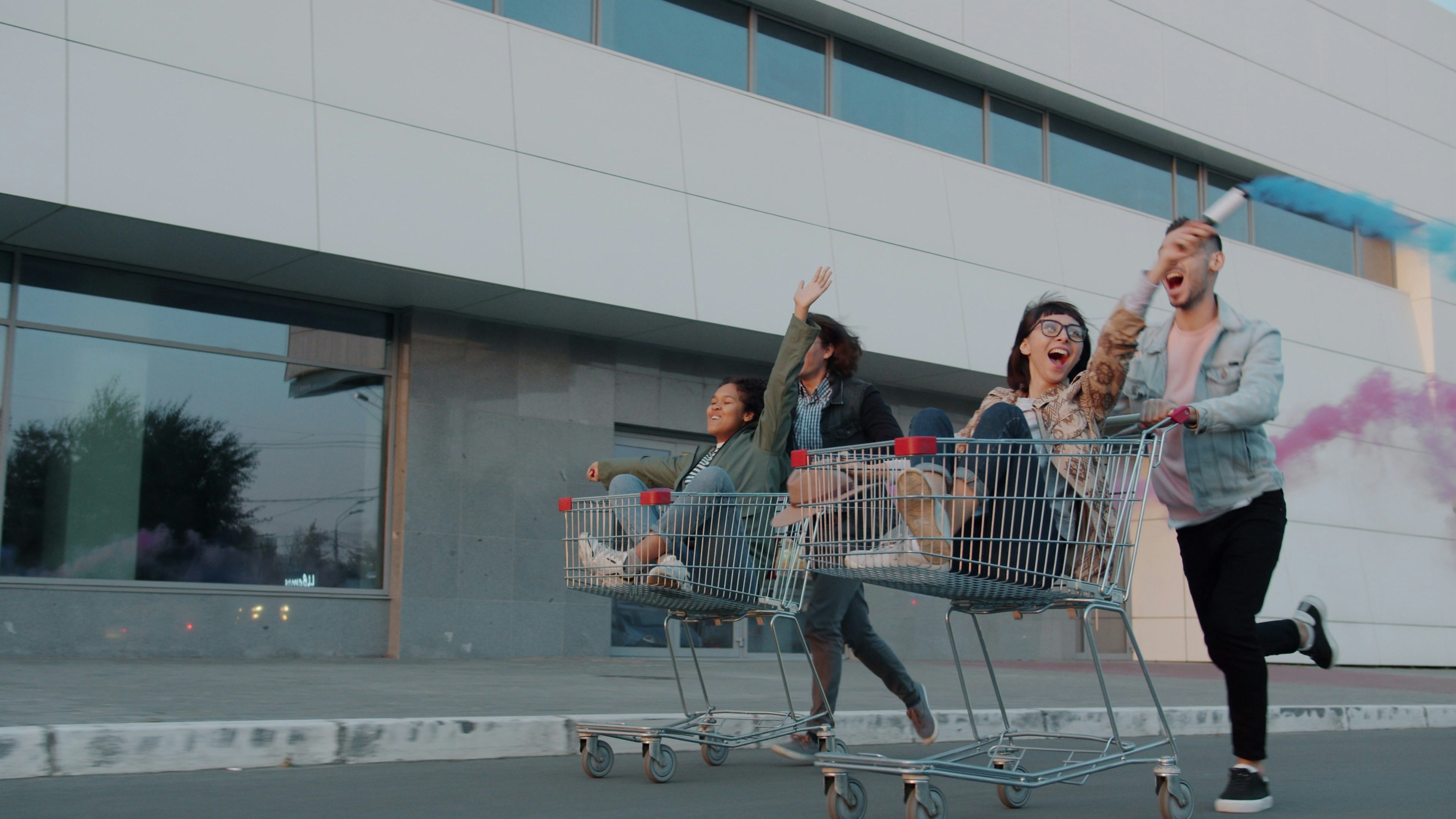 Friends joyfully riding in shopping carts outdoors