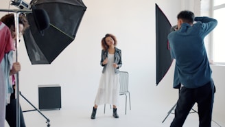 Photographer taking picture of woman in studio.