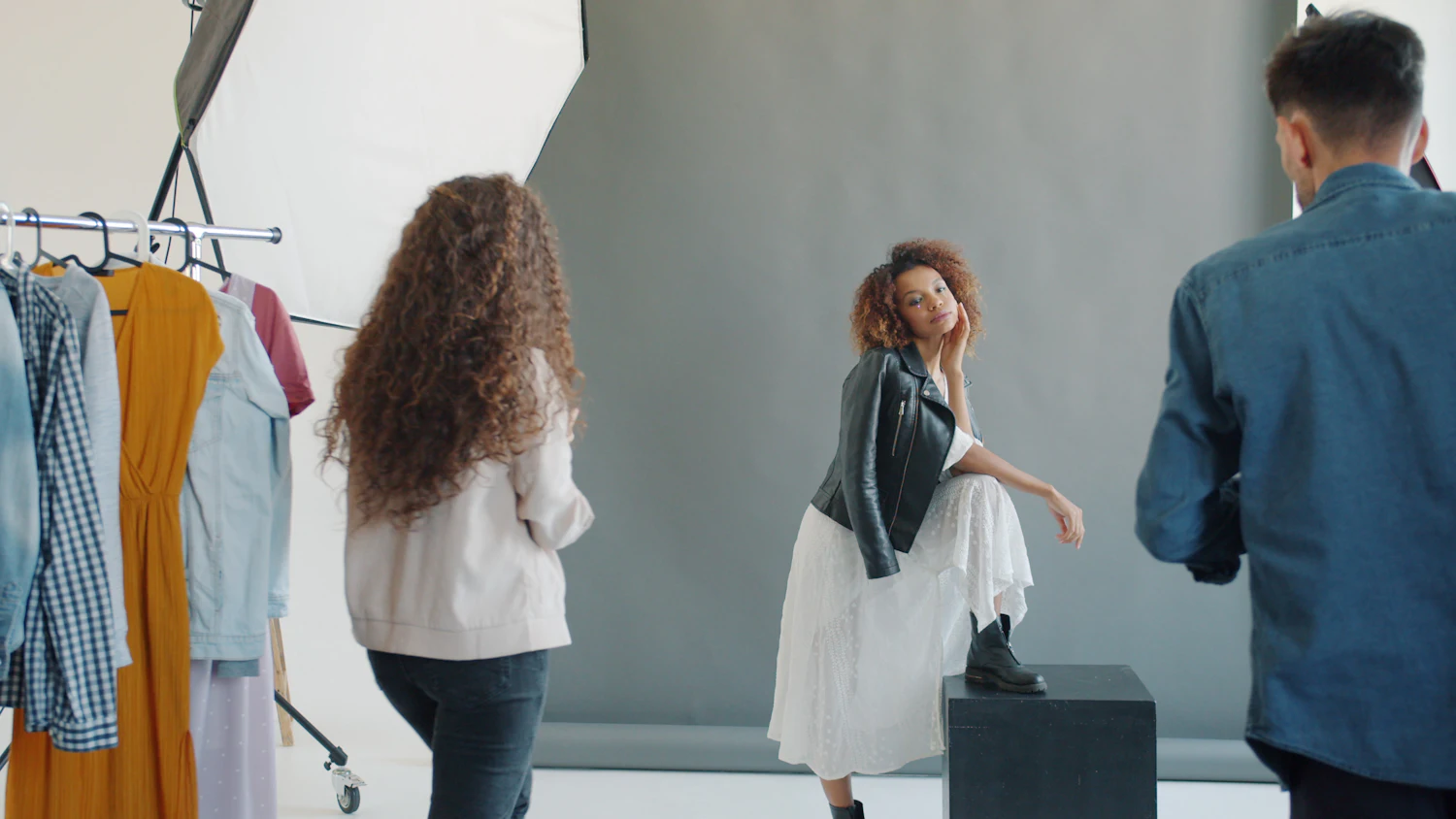 Model posing with photographer and stylist in studio