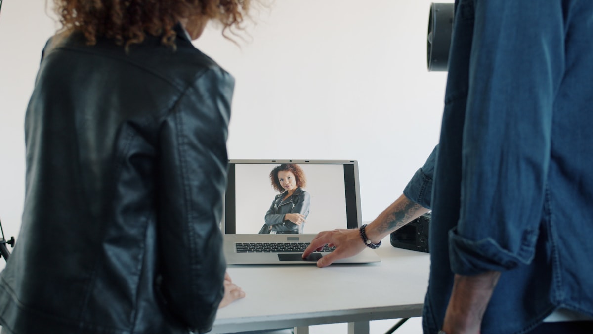 A creative team reviewing fashion content together at a screen, mid-production curation