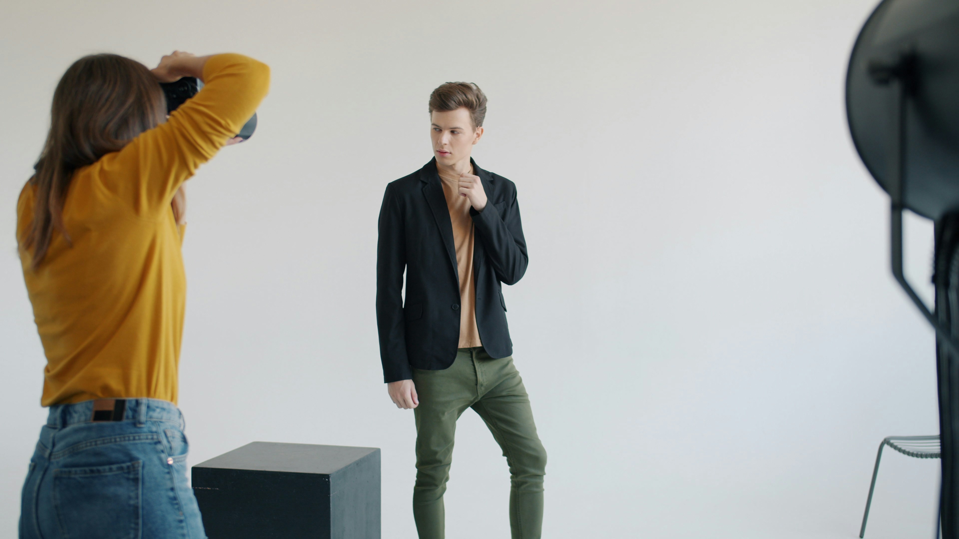 Woman photographing stylish man in studio