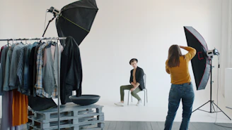 Photographer directing model in a studio photoshoot.