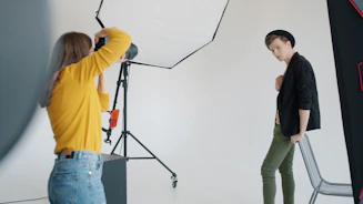 Photographer taking picture of a young man posing.